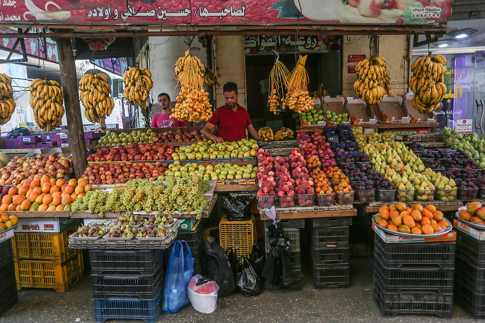 Palestinians shop at a market ahead of the Eid al-Adha festival, in Khan Younis in the southern Gaza Strip