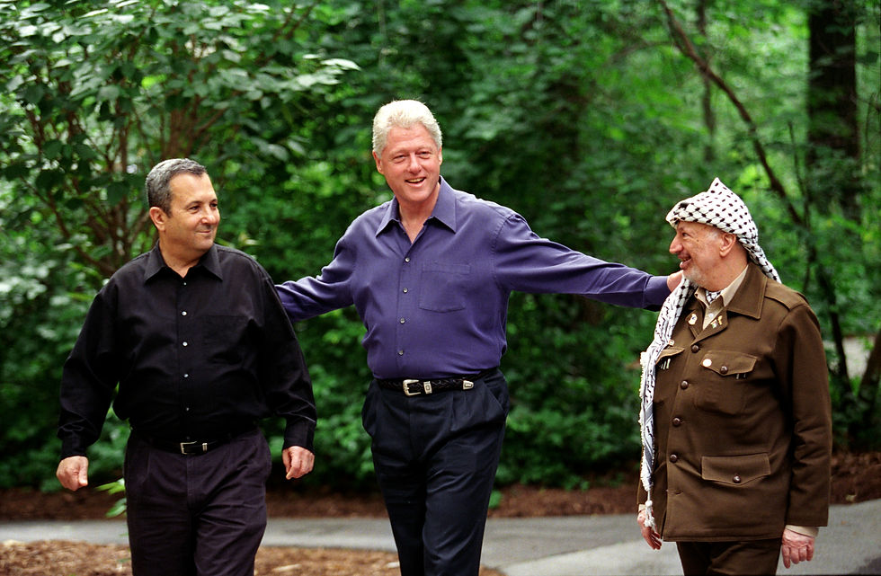 President Clinton walks with Prime Minister Ehud Barak of Israel and Yasser Arafat of the Palestinian Authority on the grounds of Camp David