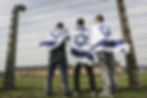 Students wearing the flag of Israel on visit Auschwitz Birkenau, in Poland