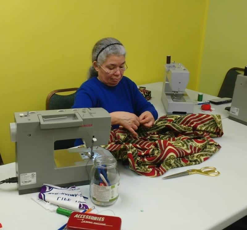 A lady sewing on a sewing machine