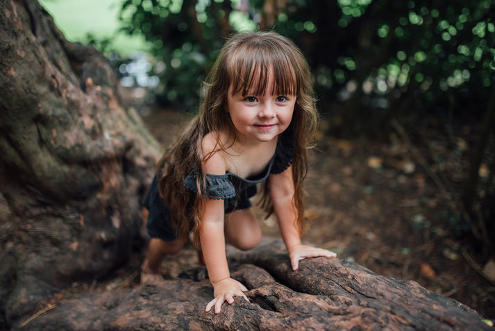 A girl climbing a tree during a fun family photoshoot with Tara Gillen Family Photographer in Bedford