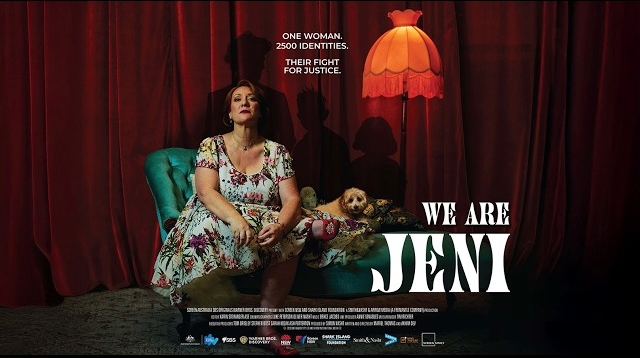 Woman in floral dress sits on teal chair next to a dog. Red curtains and lamp create a dramatic mood. Text: "We Are Jeni."