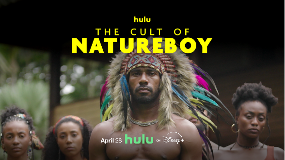 Man in vibrant feathered headdress stands with three people. Text: "The Cult of NatureBoy." Hulu and Disney+ logos. Mood: serious.