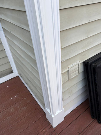 Completed siding and exterior corner trim repair beside a residential deck