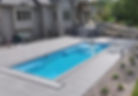 High angle view of a fiberglass pool with clear blue water and surrounding patio