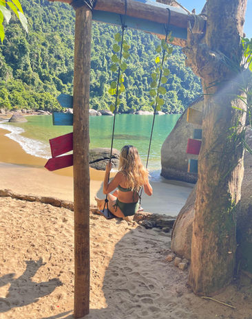 Mulher relaxa em balanço na praia paradisíaca