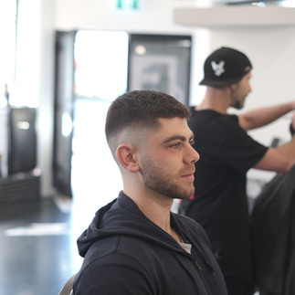 Mid skin fade with the top as short as the fingers can go, with a faded clean cropped beard