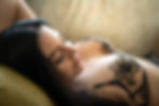 Salt Lake City GFE Escort lounging in lingerie on the couch with eyes closed and a gentle expression
