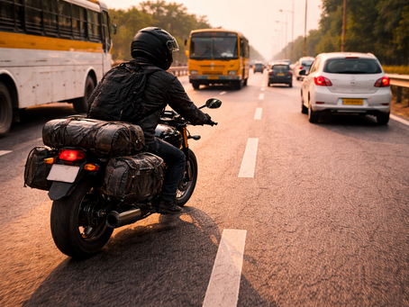 Motorcyclist riding in correct lane position on an Indian highway with traffic around