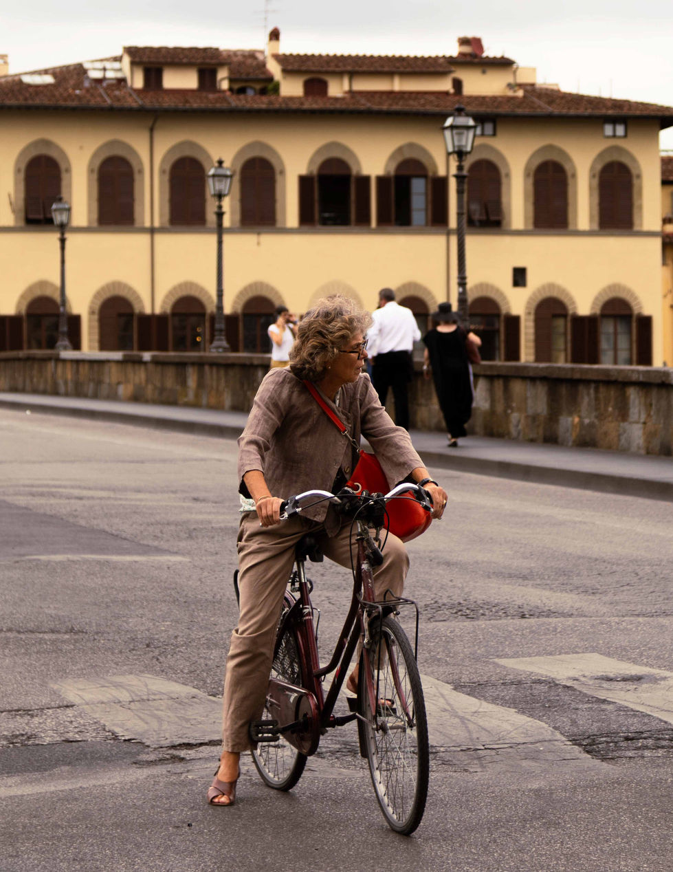 Woman stopped at intersection on bike. 