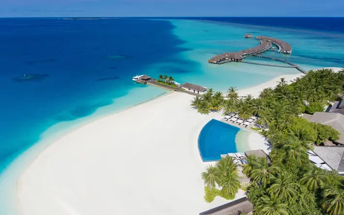 Infinity pool at Velassaru Maldives, perfectly positioned with views extending over the turquoise lagoon.