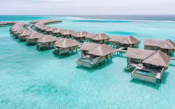 Overwater villas at Vakkaru Maldives with private sundecks overlooking the turquoise lagoon in Baa Atoll.