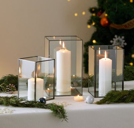 Three glass candle holders with white candles