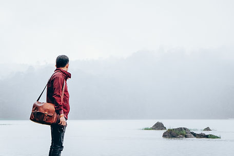 Man with messenger ba looking over landscape