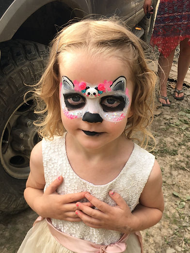Young girl has panda mask with small plastic panda Keepsake on forehead. She has her hands clasped.