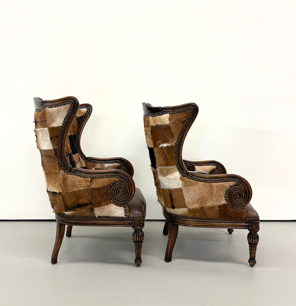 Thumbnail: Vintage Carved Wood Patchwork Cowhide Wingback Chairs - Pair