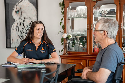 Physiotherapist smiling whilst engaging with client, gathering information