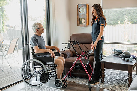 Physiotherapist standing with client in wheelchair during transfers