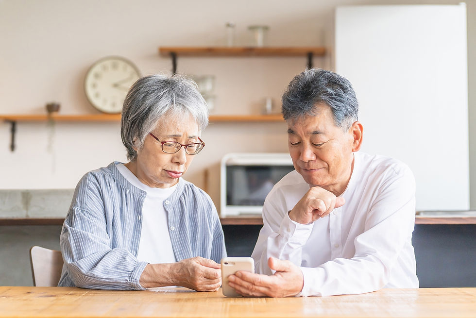 自宅で老人ホームの情報を調べながらケアトップワンへの無料相談を検討するシニア夫婦