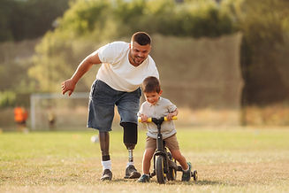 Amputee playing with a child on a bike.