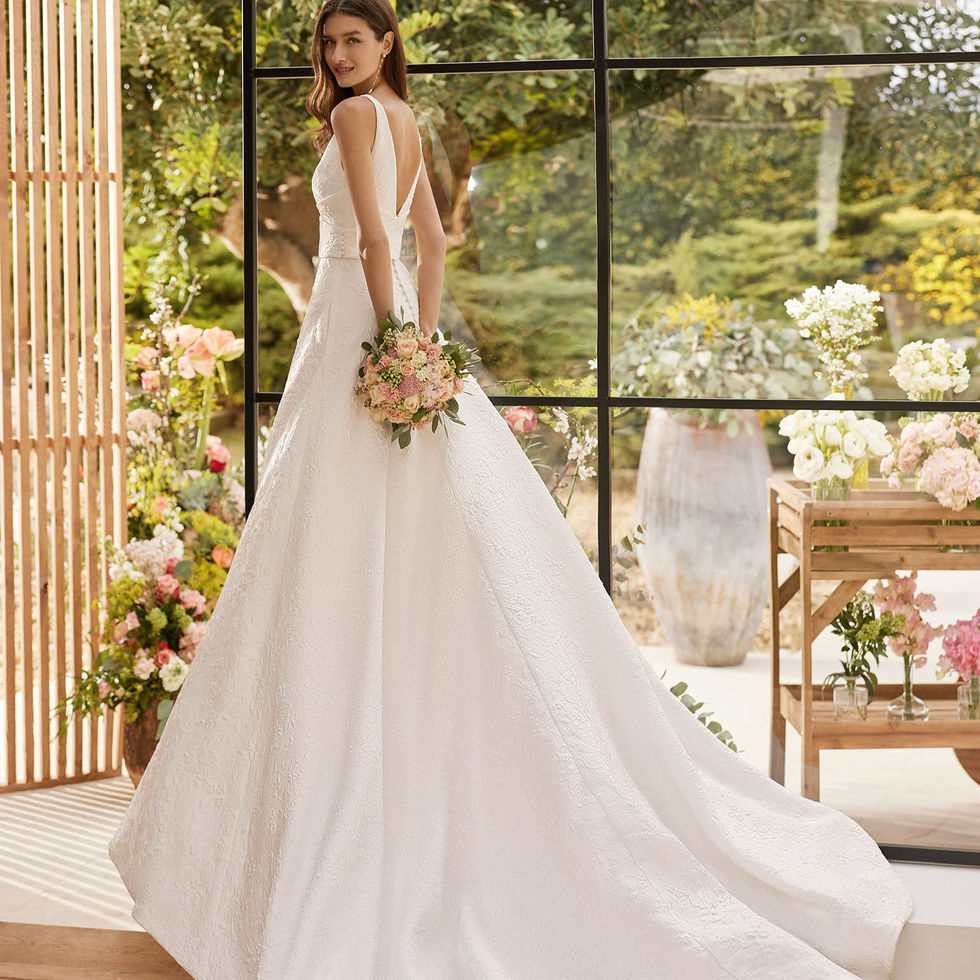 Sposa in abito bianco con bouquet posa per foto. A20. Sposami Atelier.