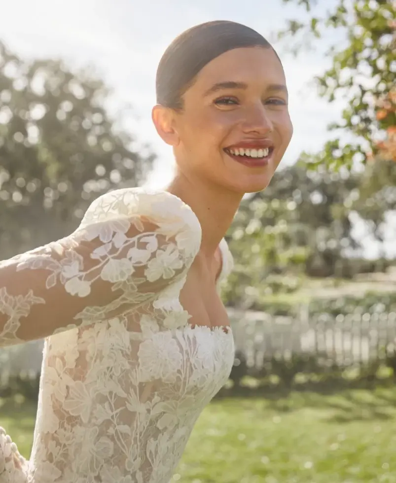 Sorridendo sposa in abito bianco con maniche lunghe, A20. Sposami Atelier.