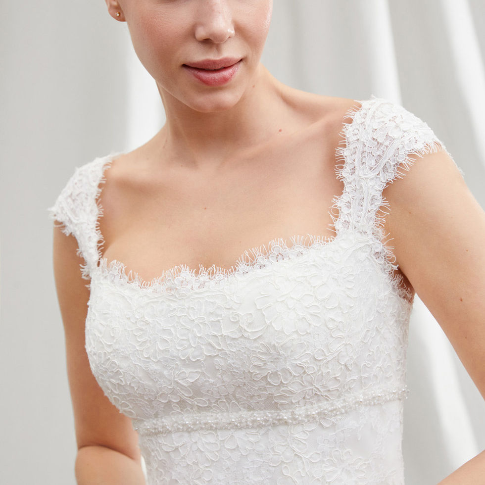 Sposa sorridente indossa abito bianco in pizzo, dettaglio della spallina quadrata, Sposami Atelier.