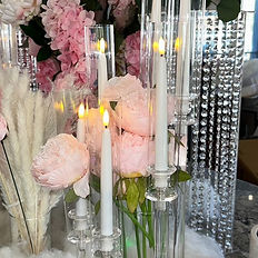 An elegant candle display surrounded by lush blooms, creating a warm and sophisticated ambiance for upscale events.