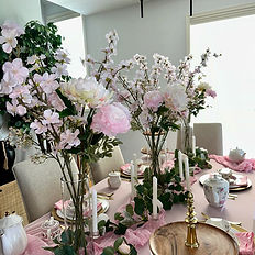 A meticulously styled tea party with bespoke table linens, gold-trimmed teaware, and hand-selected floral arrangements, designed for an unforgettable experience.