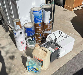 Old paint cans and hazardous waste staged for proper disposal in Shelburne Vermont