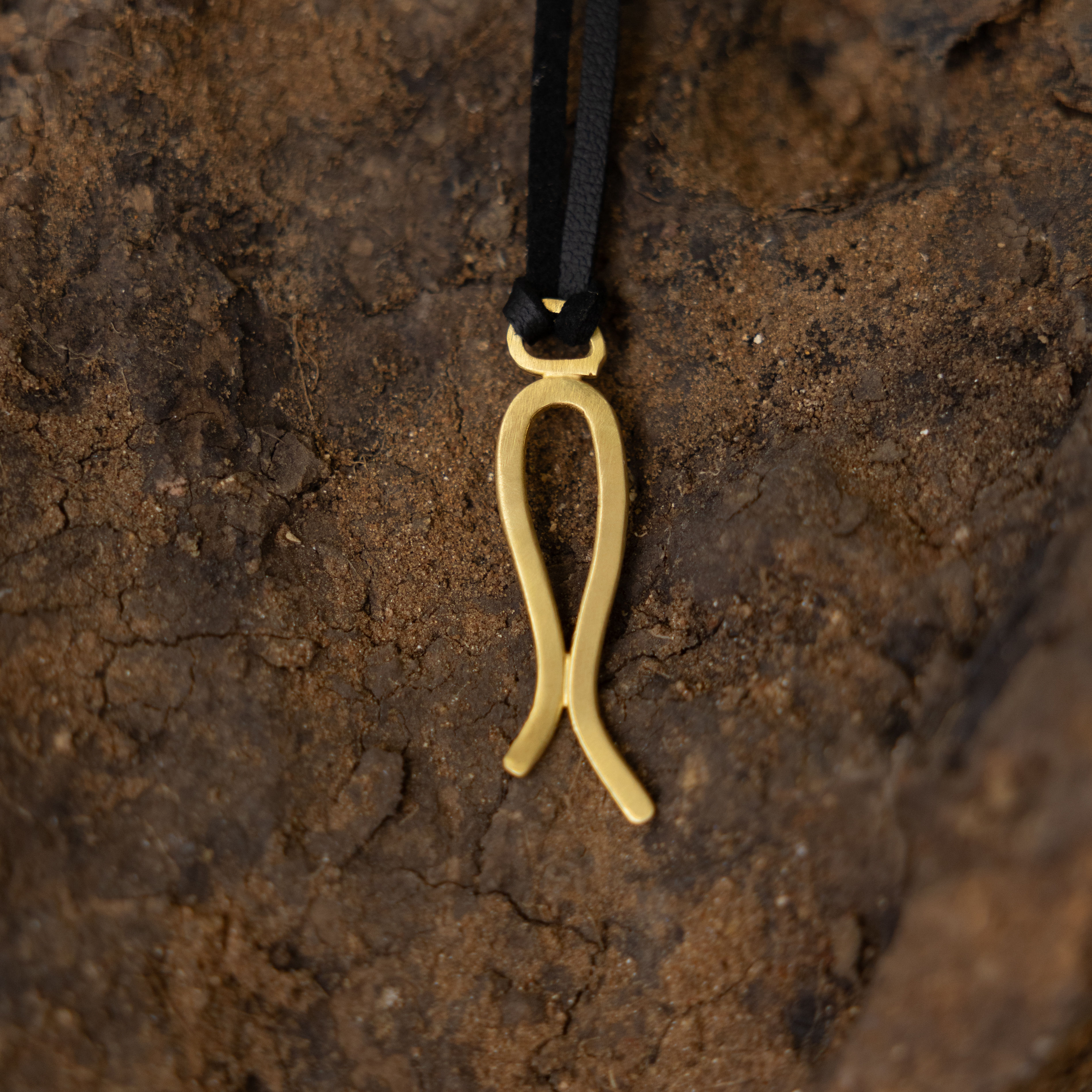 תליון זהב עתיק על רקע חום כהה