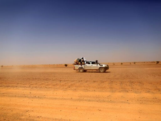 Indigenous Sahrawi people sit on a pick-up truck as they drive towards Tifariti, Western Sahara