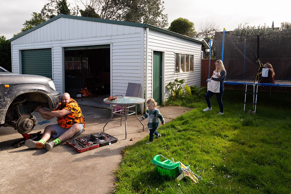 family with kids playing outside whilst dad fixes wheel on four wheel drive vehicle