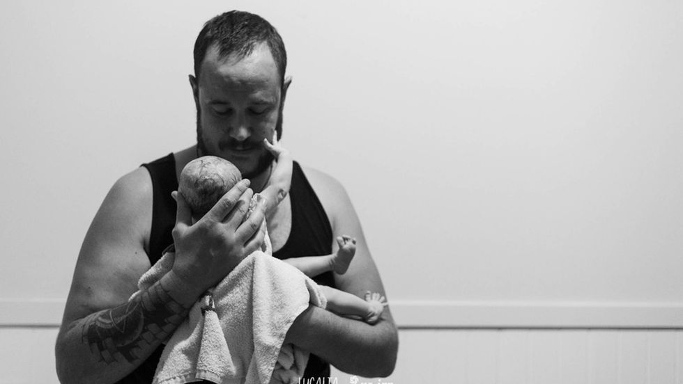 Real Family Photography dad holding his newborn daughter for the first time Blenheim