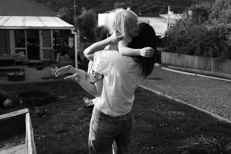 young girl having a tantrum held by her mum outside
