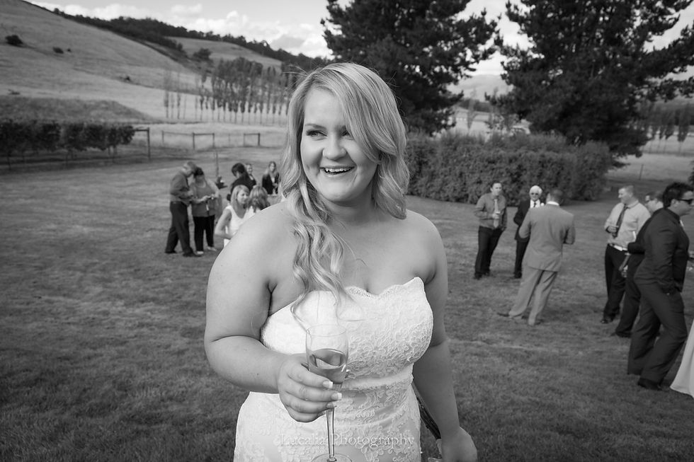 bride holding champagne at her outdoor wedding