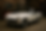 white MG Midget convertible down in a vintage workshop with soft lighting accentuating the