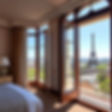 a luxury hotel room with a balcony and french doors opening onto a view of Paris and the E
