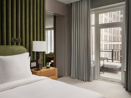 Guest room with balcony overlooking skyscrapers