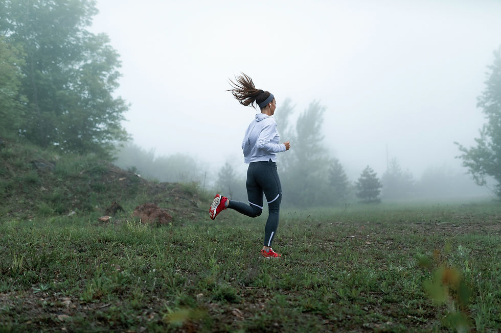 Women running across a field in the rain