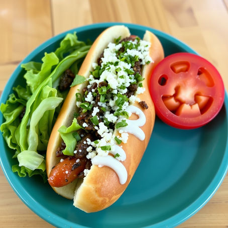 hot dog sandwich with slice of tomato and lettuce sitting in a plate