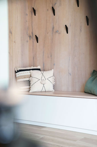 Eine gemütlich eingelassene Sitznische rundet die handgefertigte Garderobe ab.