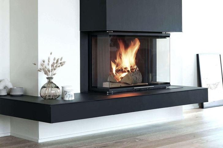 Floating fireplace in anthracite, three-sided fire view and concealed wood storage.