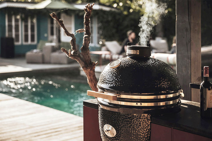 Nahaufnahme vom Monolith Kamadogrill. Der Holzkohlegrill ist in die Freiluftküche integriert und flexibel nutzbar.