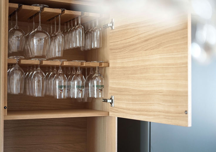 Geöffnetes Schrankfach mit hängenden Wein- und Sektgläsern.