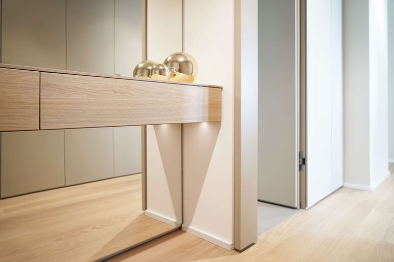 Mabian Garderobe: Holzregal vor Spiegelwand. 