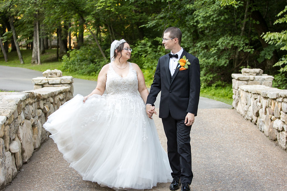 Wedding Photography of a bride and groom walking across a bridge. Photo by Aaron Clark Photography.