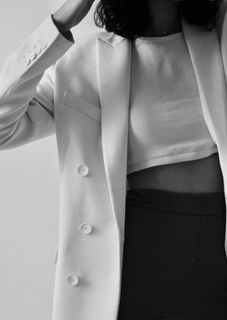 greyscale photo of a women silhouette in a blazer, cropped top, and black trousers