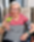 older lady in a buckinghamshire care home pictured outside. She is sitting down and had a mocktail filled with fresh fruit in a martini glass in her hand.