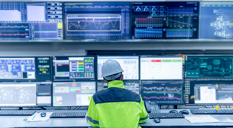 Engineer infront of multiple screens showing charts and graphs